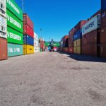 Colorful shipping containers stacked at Muuga Port under a clear blue sky.